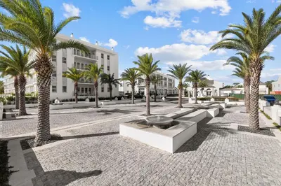 a courtyard with palm trees and a building at Kaiya Beach Resort in Inlet Beach