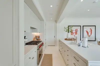 a kitchen with white cabinets and a stove top oven at Kaiya Beach Resort in Inlet Beach