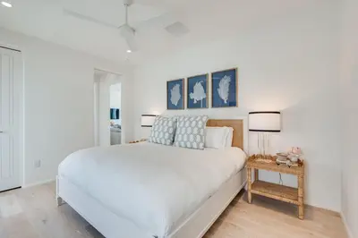 a white bedroom with a large bed and two lamps at Kaiya Beach Resort in Inlet Beach