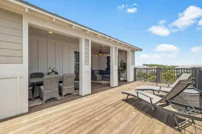 a patio with a table and chairs on a deck at Dune Our Thing by 30A Escapes in Inlet Beach