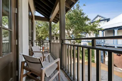 a porch with rocking chairs and a view of the street at Pappas Carriage by 30A Escapes in Rosemary Beach