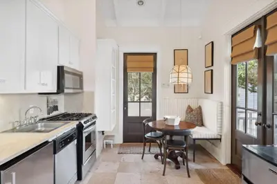 a kitchen with a sink and a table with chairs at Pappas Carriage by 30A Escapes in Rosemary Beach