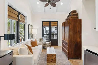 a living room with a white couch and a ceiling fan at Pappas Carriage by 30A Escapes in Rosemary Beach