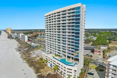 an aerial view of a tall building next to a beach at Palazzo Unit 301 by 30A Escapes in Panama City Beach