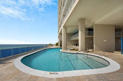 a swimming pool with the ocean in the background at Palazzo Unit 301 by 30A Escapes in Panama City Beach