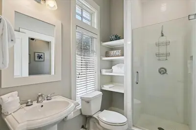 a bathroom with a toilet and a sink and a shower at Summer Cottage by 30A Escapes in Rosemary Beach