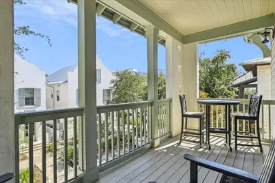 a porch with two chairs and a table on it at Summer Cottage by 30A Escapes in Rosemary Beach