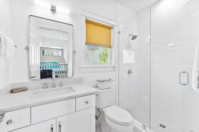 a white bathroom with a toilet and a sink at Barefoot Too by 30A Escapes in Inlet Beach