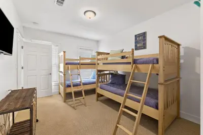 a room with two bunk beds and a tv at Barefoot Too by 30A Escapes in Inlet Beach