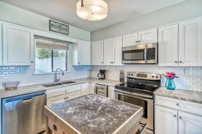 a kitchen with white cabinets and stainless steel appliances at Mermaid Cove by 30A Escapes in Seacrest