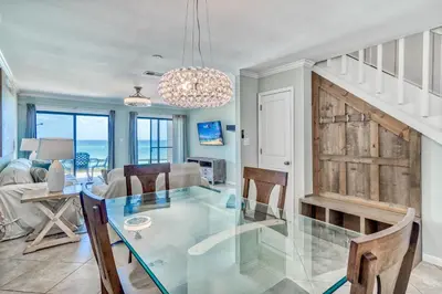a dining room and living room with a glass table at Mermaid Cove by 30A Escapes in Seacrest