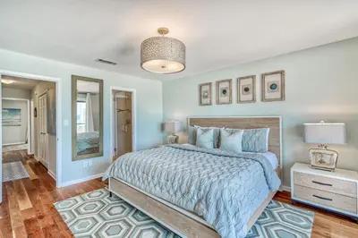 a bedroom with a large bed and a mirror at Mermaid Cove by 30A Escapes in Seacrest