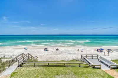 a beach with the ocean in the background at Mermaid Cove by 30A Escapes in Seacrest