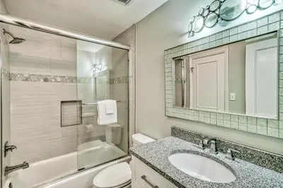 a bathroom with a sink and a toilet and a mirror at Mermaid Cove by 30A Escapes in Seacrest