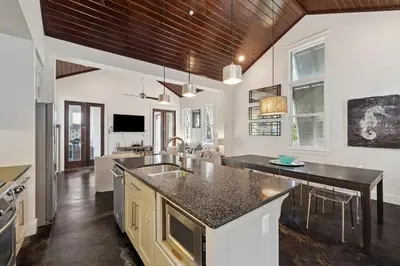 a kitchen with white walls and a wooden ceiling at Somerset Cottage by 30A Escapes in Rosemary Beach
