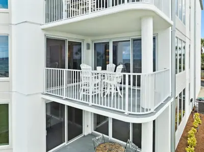 a white building with a balcony with chairs on it at Tranquillity on 30A Unit# 210 by 30A Escapes in Seacrest