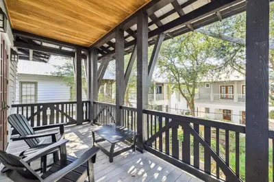 a screened porch with two chairs and a table at 21 Hamilton Lane by 30A Escapes in Rosemary Beach