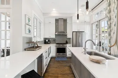 a kitchen with white cabinets and white counter tops at 21 Hamilton Lane by 30A Escapes in Rosemary Beach