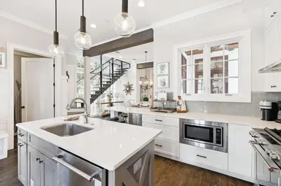 a kitchen with white cabinets and a sink at 21 Hamilton Lane by 30A Escapes in Rosemary Beach