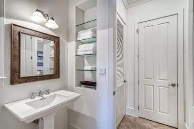 a white bathroom with a sink and a mirror at Casita By The Sea by 30A Escapes in Rosemary Beach