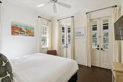 a white bedroom with a bed and a ceiling fan at Casita By The Sea by 30A Escapes in Rosemary Beach