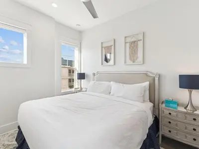 a white bedroom with a bed and two windows at CaSEAta by 30A Escapes in Rosemary Beach