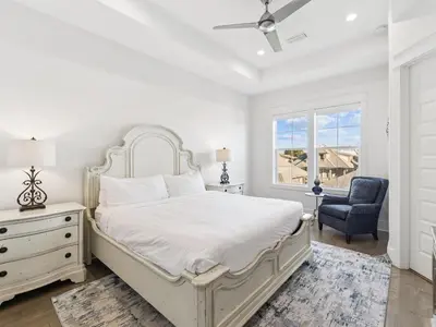 a bedroom with a bed and a chair and a window at CaSEAta by 30A Escapes in Rosemary Beach