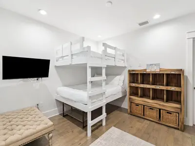 a white bunk bed in a room with a tv at CaSEAta by 30A Escapes in Rosemary Beach