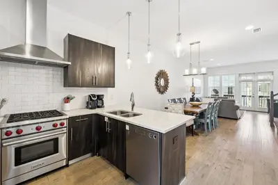 a kitchen with stainless steel appliances and a dining room at 275 Lifeguard Loop by 30A Escapes in Rosemary Beach