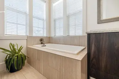 a bathroom with a white tub and windows at 275 Lifeguard Loop by 30A Escapes in Rosemary Beach