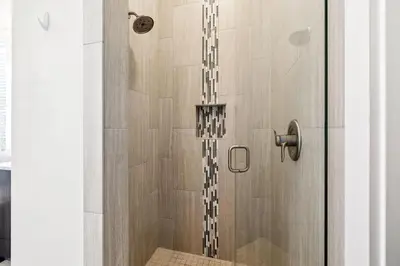 a shower stall with a glass door with a shower at 275 Lifeguard Loop by 30A Escapes in Rosemary Beach