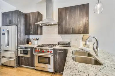 a kitchen with stainless steel appliances and wooden cabinets at Sail Away by 30A Escapes in Rosemary Beach
