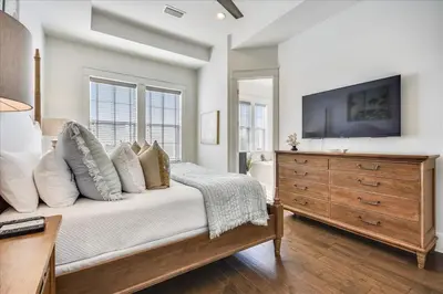 a bedroom with a bed with a dresser and a television at Sail Away by 30A Escapes in Rosemary Beach
