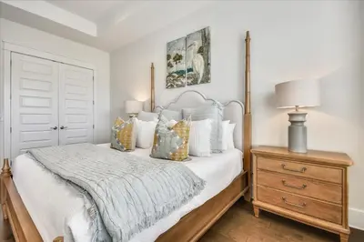 a bedroom with a bed and a dresser with a lamp at Sail Away by 30A Escapes in Rosemary Beach