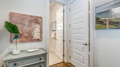 a hallway with a door and a vase on a table at Sail Away by 30A Escapes in Rosemary Beach