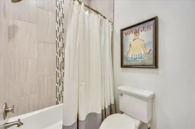 a bathroom with a shower curtain and a toilet at Sail Away by 30A Escapes in Rosemary Beach