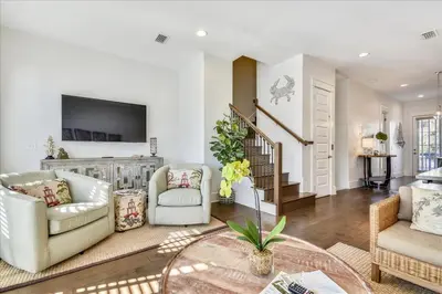 a living room with two chairs and a tv at Sail Away by 30A Escapes in Rosemary Beach