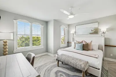 a bedroom with a bed and a table and windows at Beachfront Bliss On 30A by 30A Escapes in Seacrest
