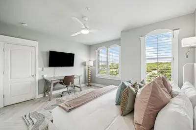 a bedroom with a white bed with a desk and windows at Beachfront Bliss On 30A by 30A Escapes in Seacrest