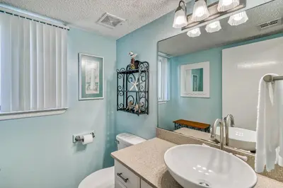 a bathroom with a sink and a toilet and a mirror at 350 Beachfront Trail Unit 4 by 30A Escapes in Seagrove Beach