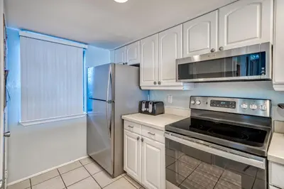 a kitchen with white cabinets and a stainless steel refrigerator at 350 Beachfront Trail Unit 4 by 30A Escapes in Seagrove Beach