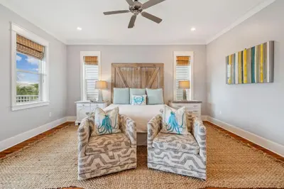 a bedroom with a bed and two chairs at Aqua Waters by 30A Escapes in Rosemary Beach