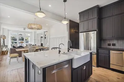 a kitchen with black cabinets and a white counter top at HollieBird House by 30A Escapes in Watersound Beach