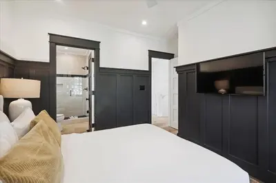 a bedroom with a large white bed and a television at HollieBird House by 30A Escapes in Watersound Beach