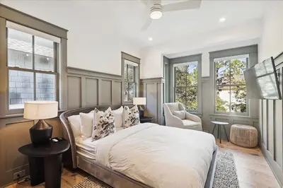 a bedroom with a bed and a chair and windows at HollieBird House by 30A Escapes in Watersound Beach
