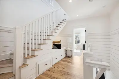 a white staircase in a home with white walls and wooden floors at HollieBird House by 30A Escapes in Watersound Beach