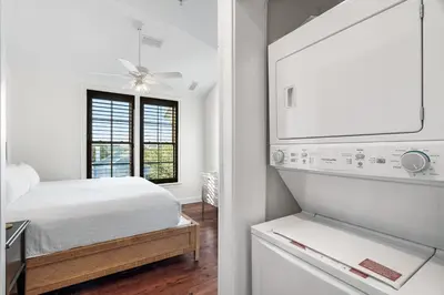 a white bedroom with a bed and a refrigerator at Rosemary Thyme by 30A Escapes in Rosemary Beach
