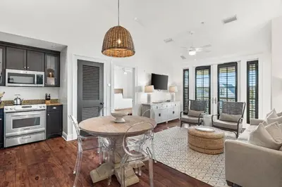 a kitchen and living room with a table and a couch at Rosemary Thyme by 30A Escapes in Rosemary Beach