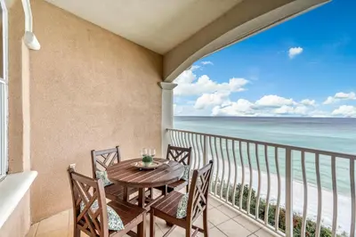 a balcony with a table and chairs and the ocean at Castle in the Sand by 30A Escapes in Seacrest