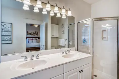a bathroom with two sinks and a large mirror at Castle in the Sand by 30A Escapes in Seacrest